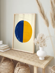 Abstract art print of a large circle divided vertically into a textured blue half and a, in an alternate framed mockup