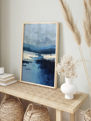 Blue abstract landscape art print with layered mountains, textural river, and white banks, in an alternate framed mockup