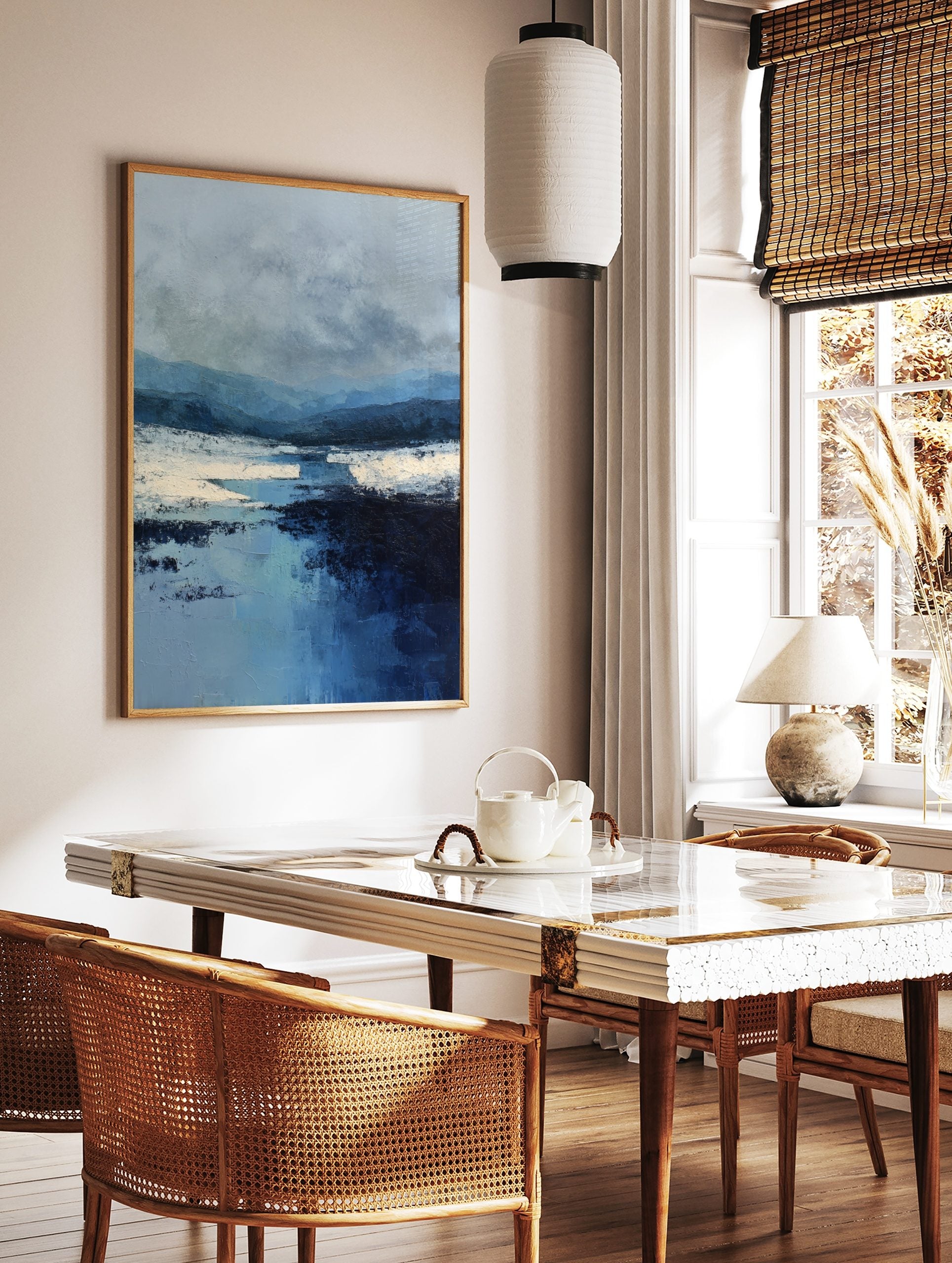 Blue abstract landscape art print with layered mountains, textural river, and white banks under a, in a styled room mockup