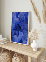 Close-up of blue abstract art with textured, flowing brushstrokes in indigo and cobalt tones, in an alternate framed mockup