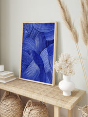 Blue abstract wall art with textured, overlapping curved brushstrokes and fine parallel lines, in an alternate framed mockup