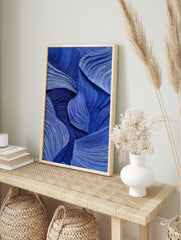 Abstract blue wall art with flowing, textured wave-like lines and layered forms, creating, in an alternate framed mockup