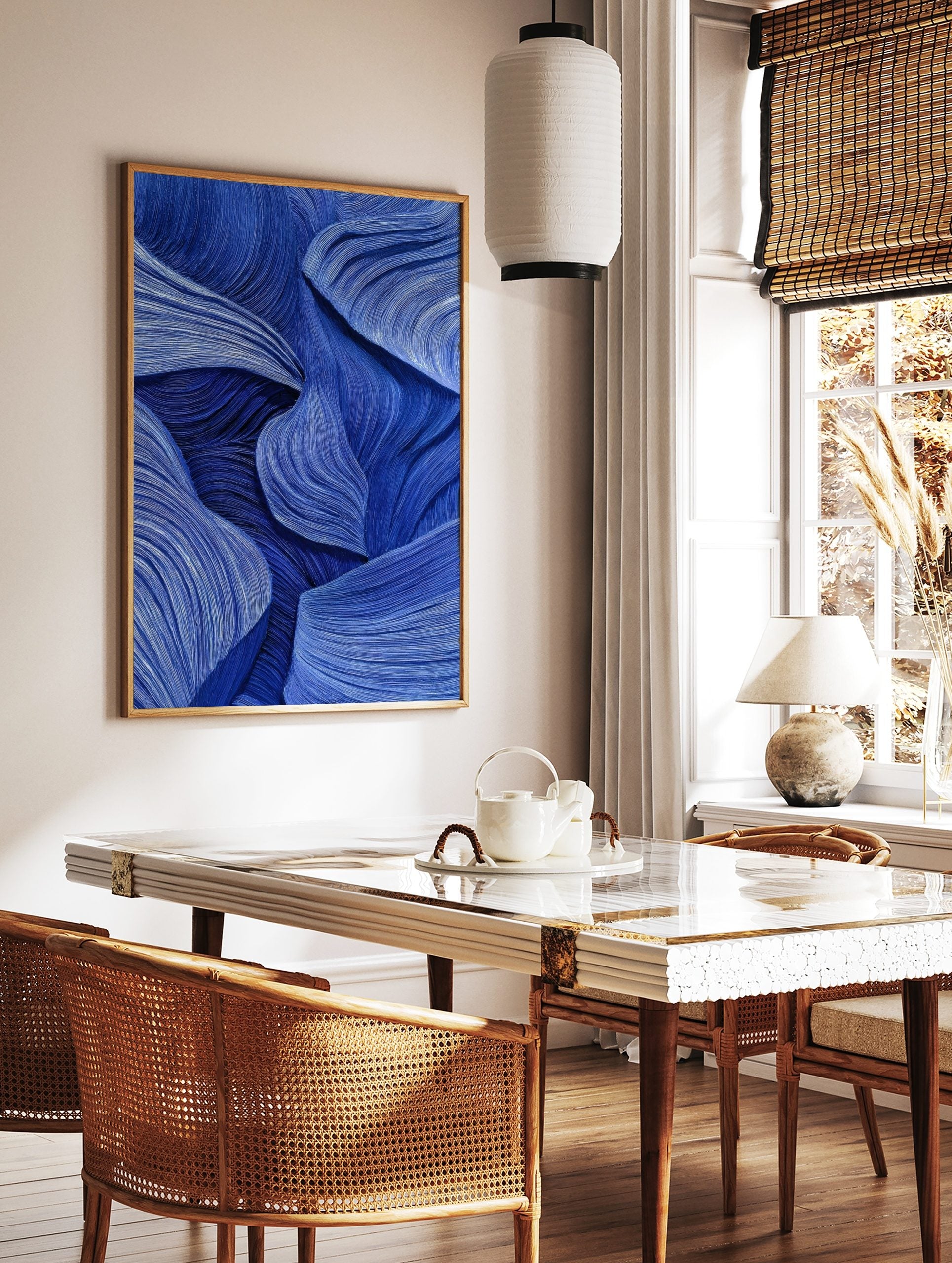 Abstract blue wall art with flowing, textured wave-like lines and layered forms, creating depth and, in a styled room mockup