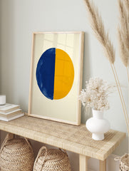 Abstract art print with a large circle split vertically into a textured blue half and a, in an alternate framed mockup