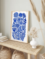 Blue botanical flower illustration art print with dense stylised floral forms on white, in an alternate framed mockup