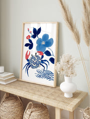 Blue crab with patterned shell, blue flowers, and red buds illustration art print on white, in an alternate framed mockup