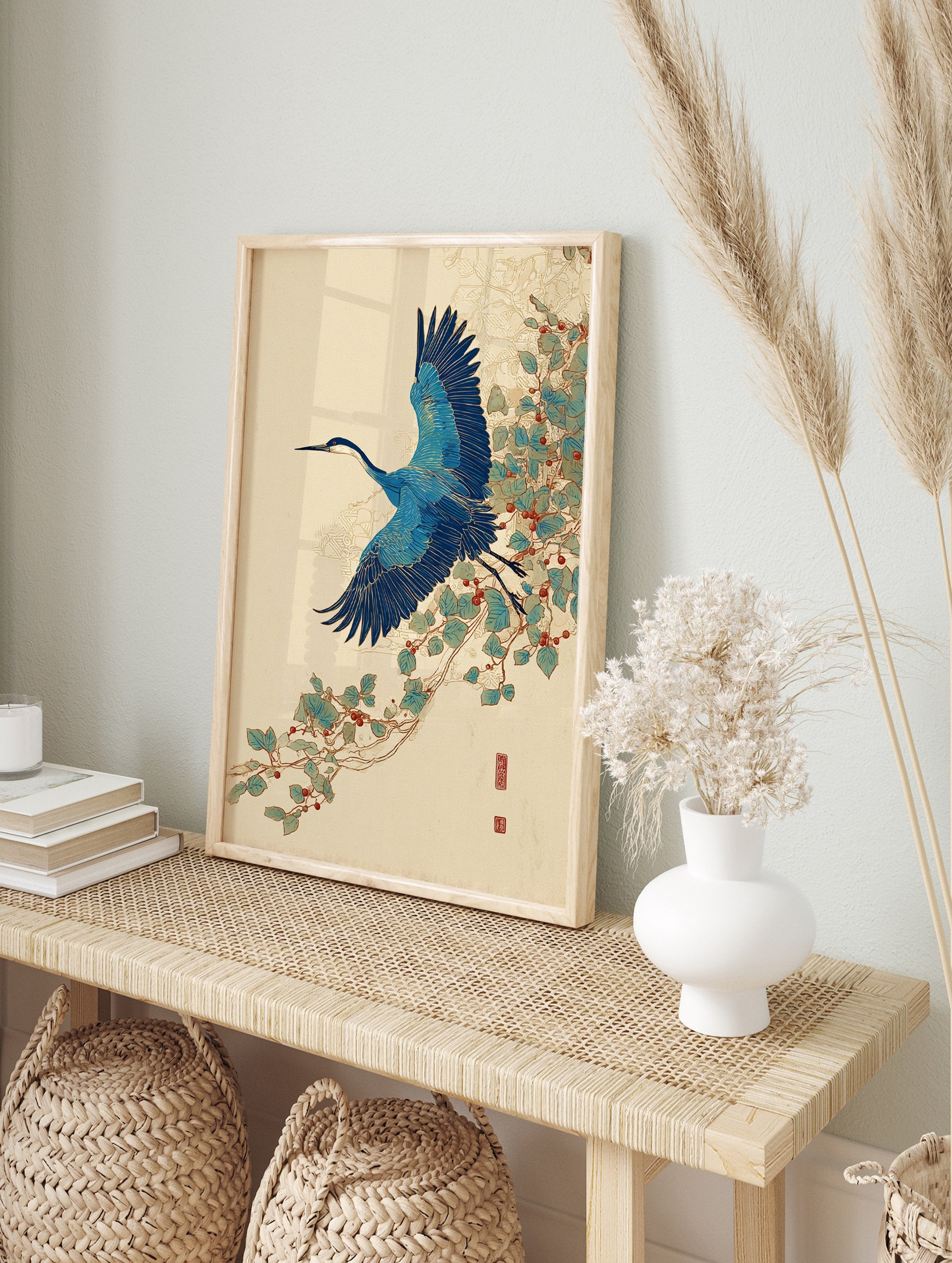 Japanese blue crane wall art print in flight with blue wings and long beak, flying past green leaves and red berries on a vine. - Image 3