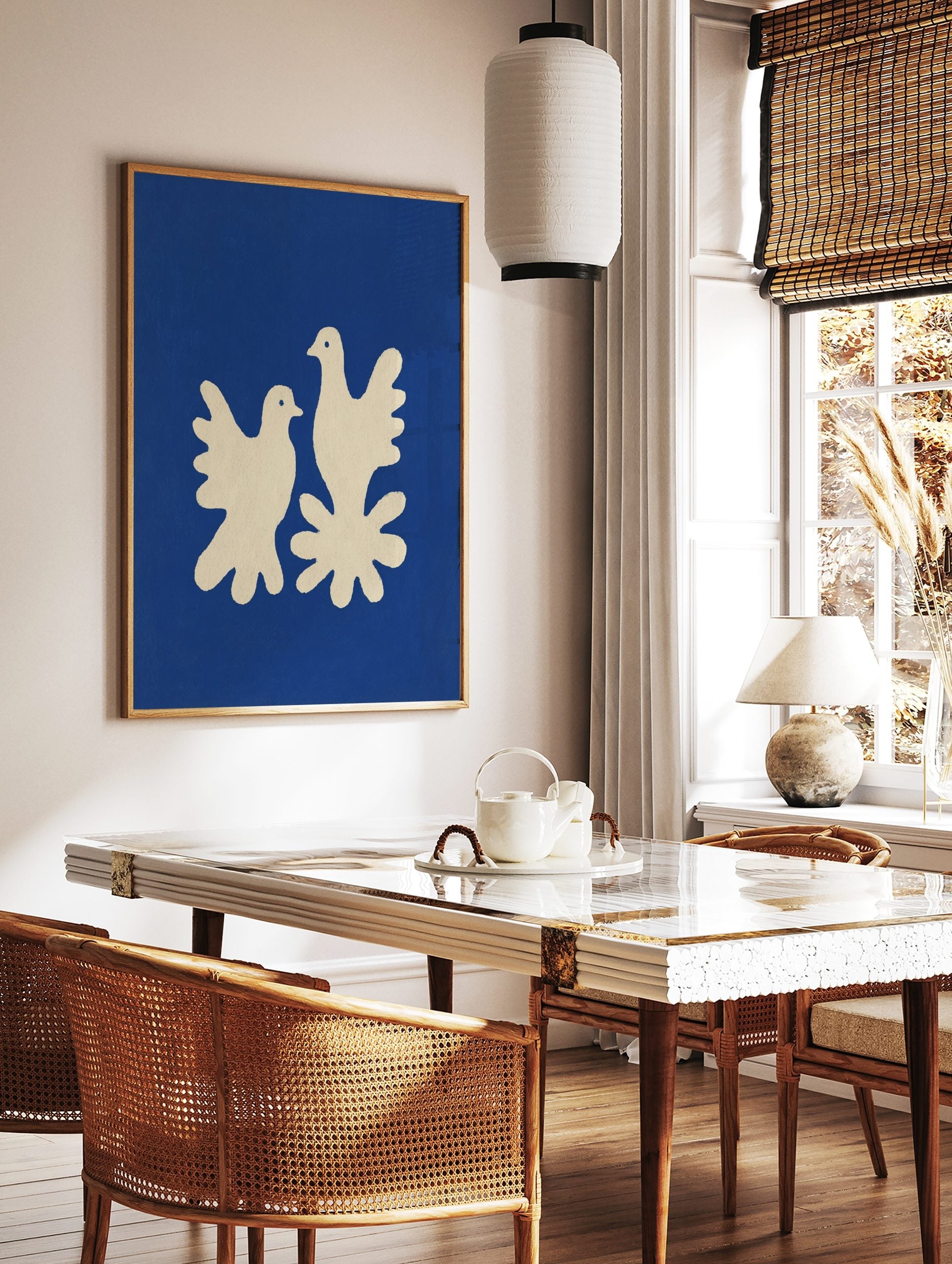 Minimalist art print of two cream doves on a deep blue background with a textured, cut-out style, in a styled room mockup