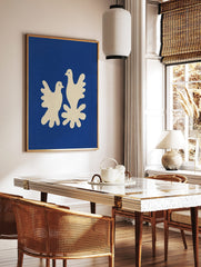 Minimalist art print of two cream doves on a deep blue background with a textured, cut-out style, in a styled room mockup