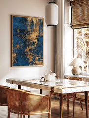 Abstract wall art print with deep blue background and distressed metallic gold textures, in a styled room mockup