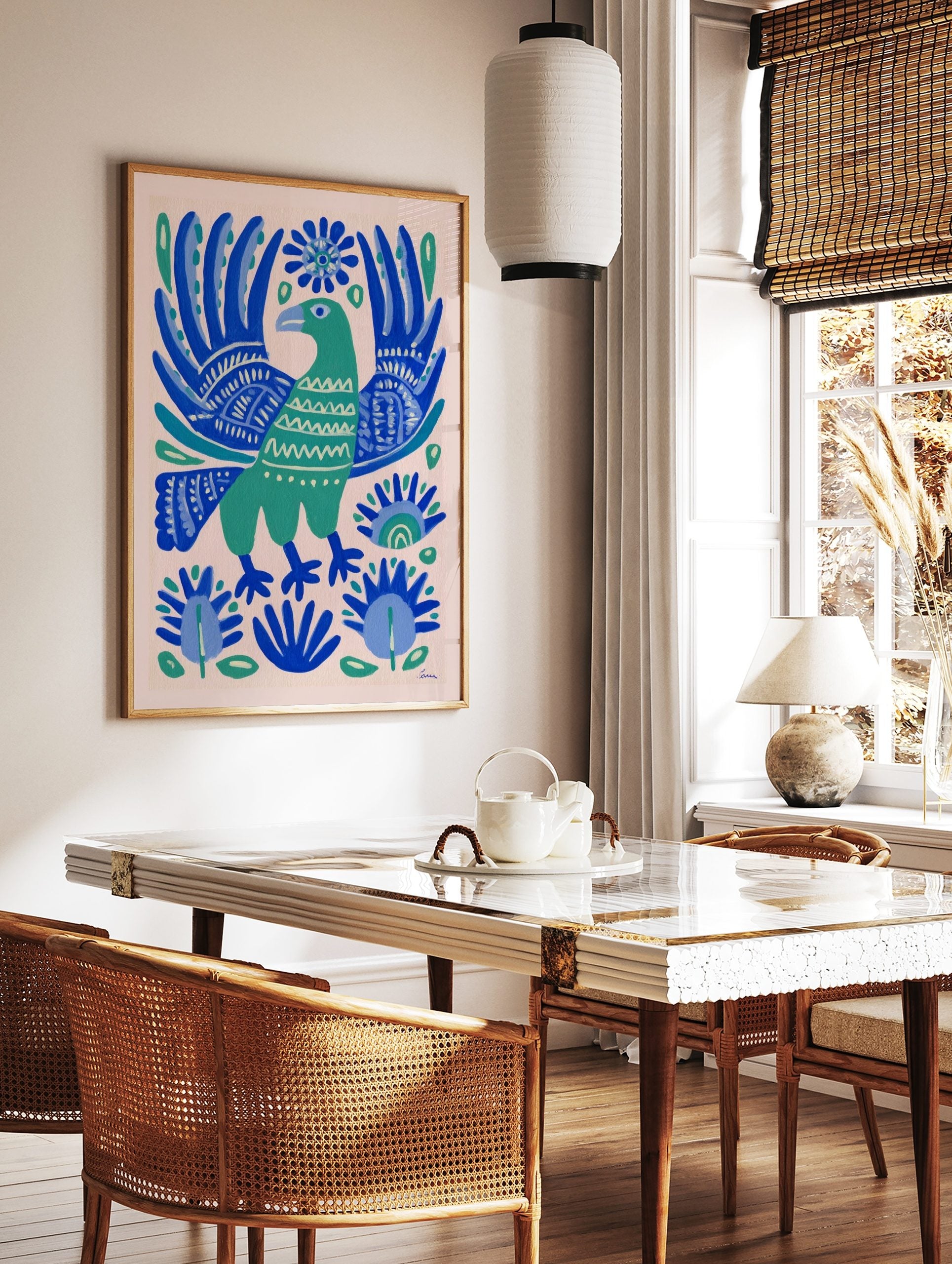 Green folk art bird with ornate blue wings and botanical patterns on a light background, in a styled room mockup