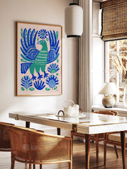Green folk art bird with ornate blue wings and botanical patterns on a light background, in a styled room mockup