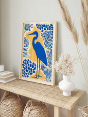 Blue heron bird silhouette art print with abstract blue and yellow shapes on a cream, in an alternate framed mockup