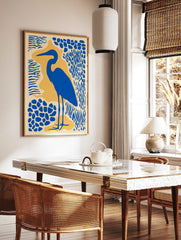 Blue heron bird silhouette art print with abstract blue and yellow shapes on a cream background, in a styled room mockup