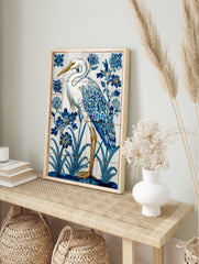 White heron with blue and gold feathers standing in water with blue flowers, in a tile-style, in an alternate framed mockup
