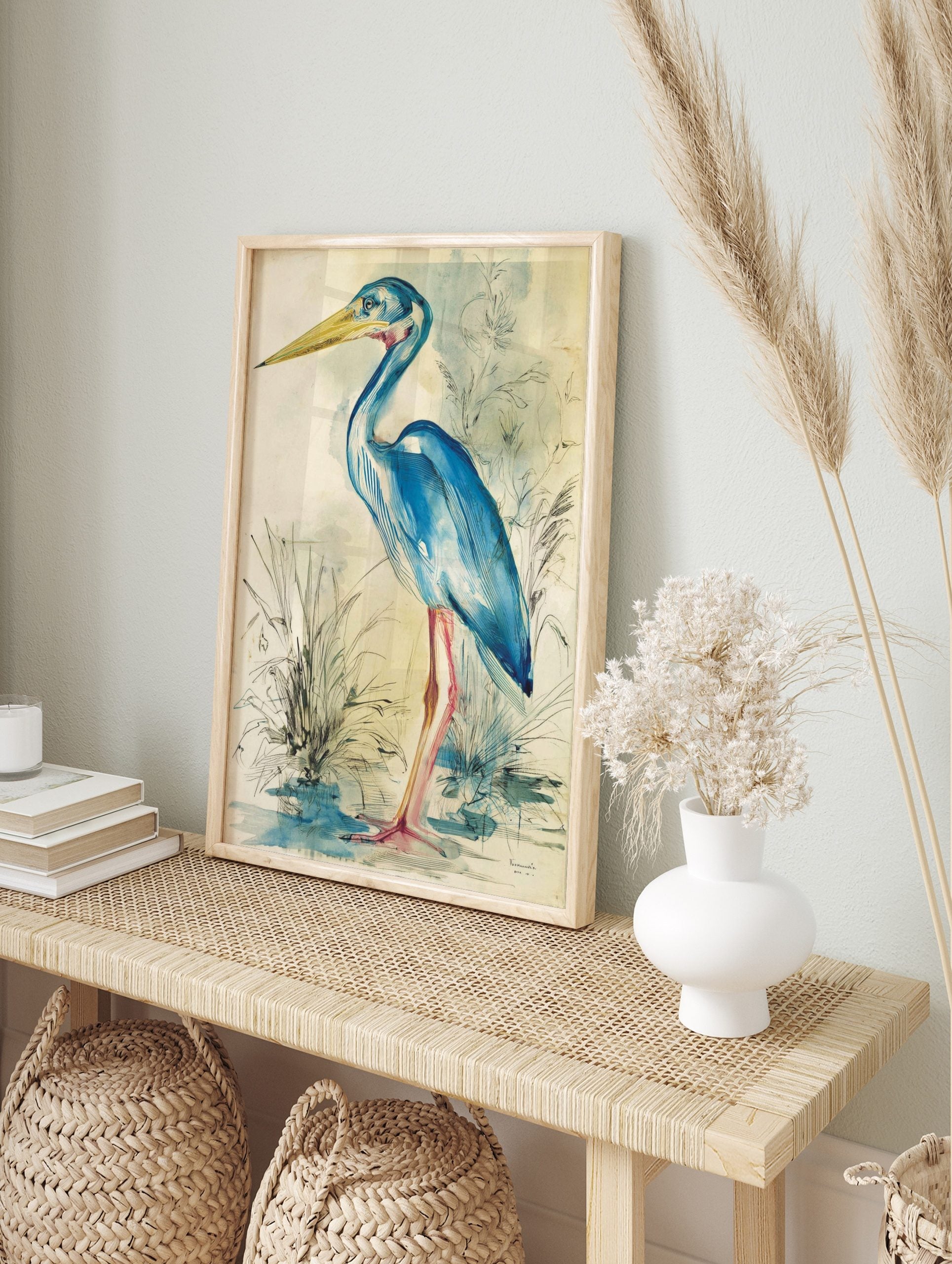 Blue heron bird illustration wall art in watercolour and ink with a yellow beak and pink legs, in an alternate framed mockup