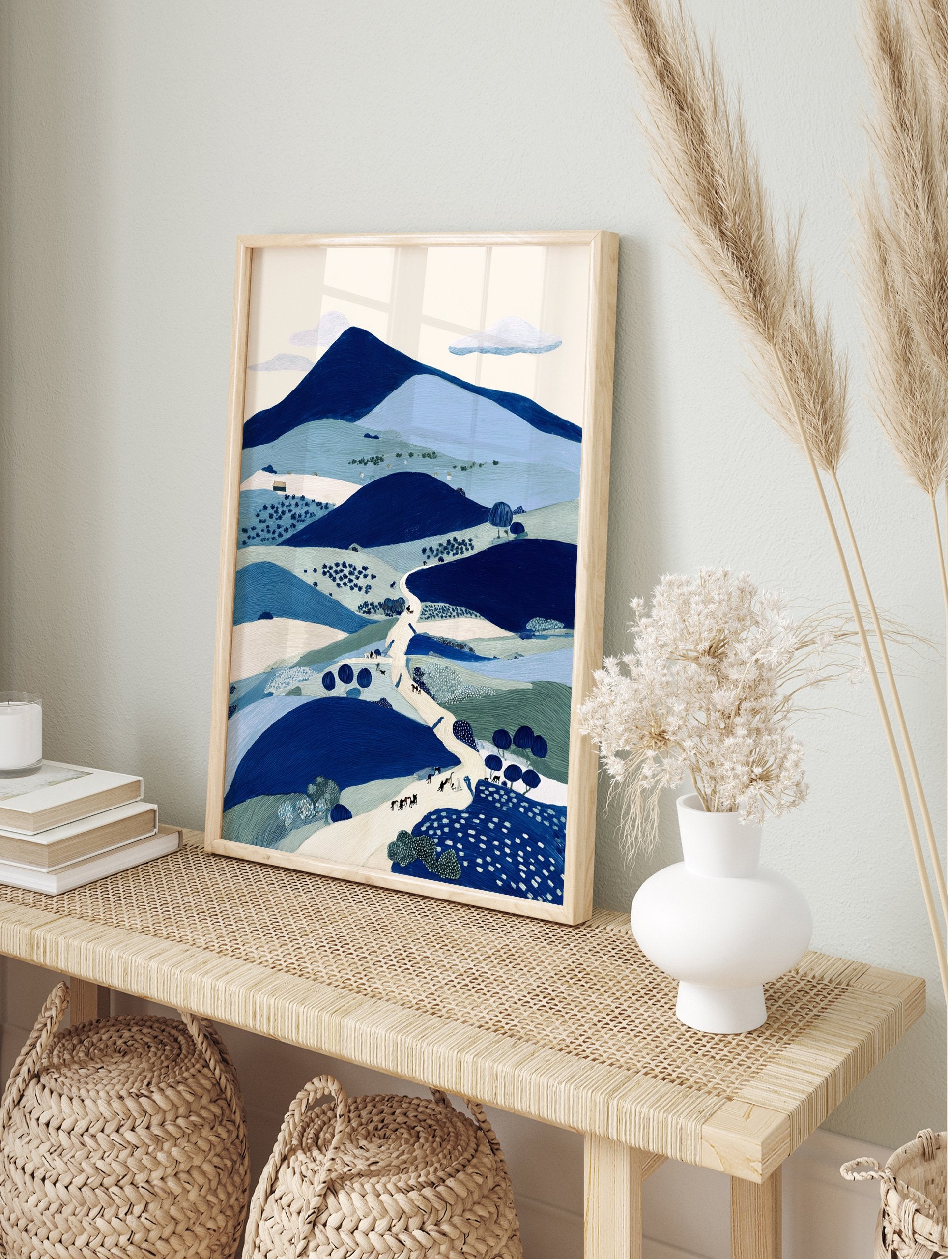 Illustrative blue landscape wall art print featuring mountains, hills, a winding path with figures, and trees. - Image 3