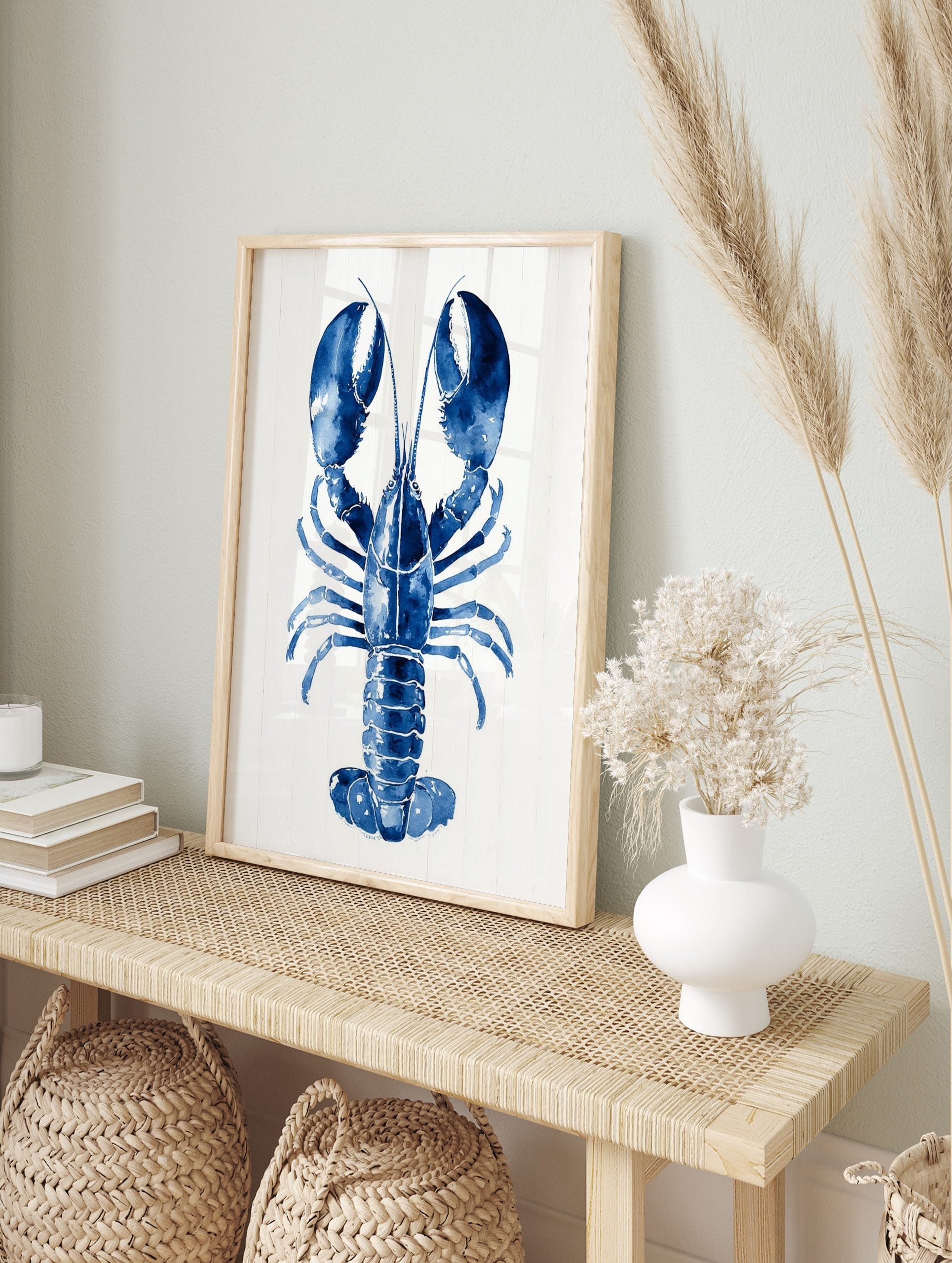 Blue lobster watercolour illustration art print with large claws on a white plank background, in an alternate framed mockup