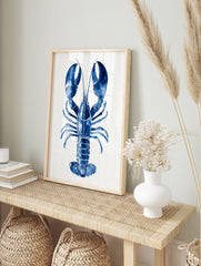 Blue lobster watercolour illustration art print with large claws on a white plank background, in an alternate framed mockup
