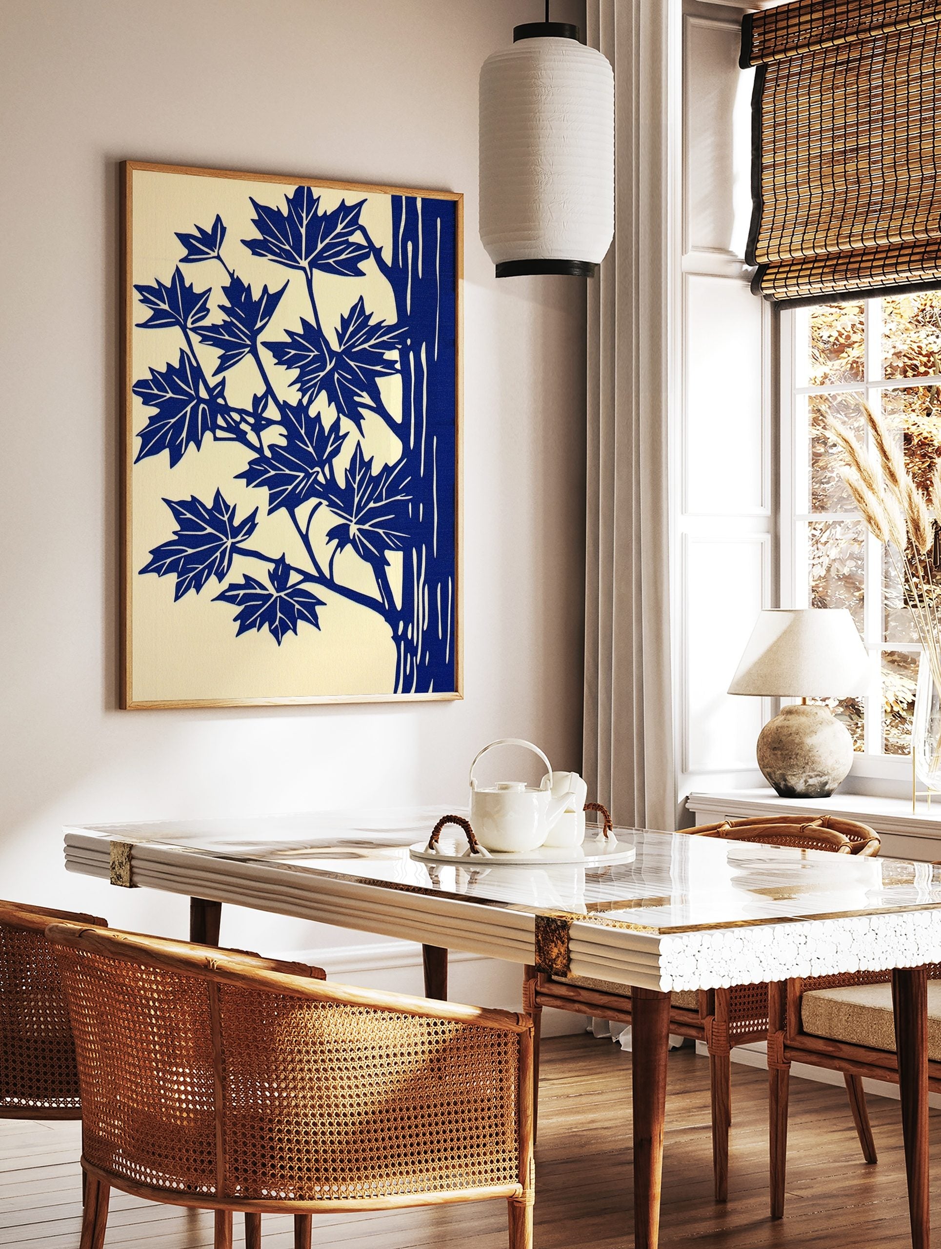 Illustrative blue maple leaves and tree trunk art print on a cream background, portrait orientation, in a styled room mockup