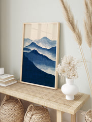 Minimalist blue mountain landscape wall art print with layered peaks and misty atmospheric, in an alternate framed mockup