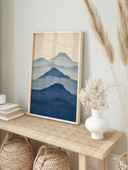 Minimalist mountain landscape wall art with layered blue silhouettes and fabric texture on a, in an alternate framed mockup