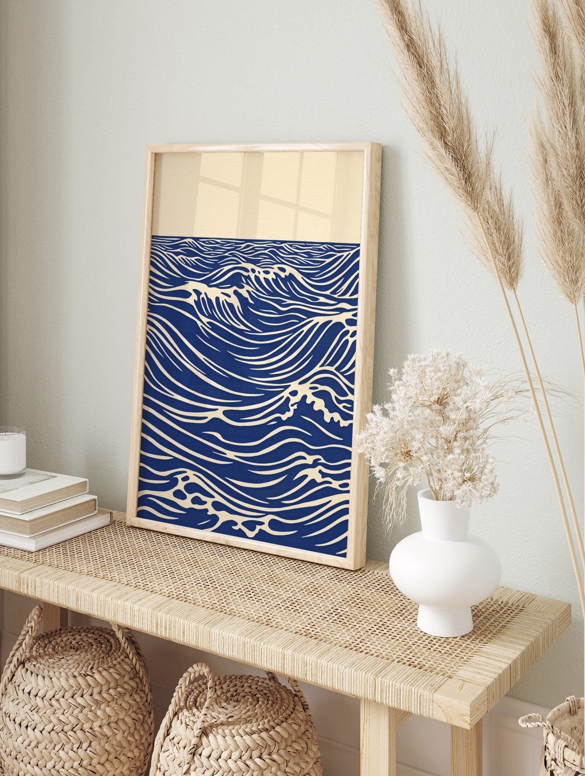 Stylised blue ocean waves with white crests and horizon line on an unframed paper print, in an alternate framed mockup