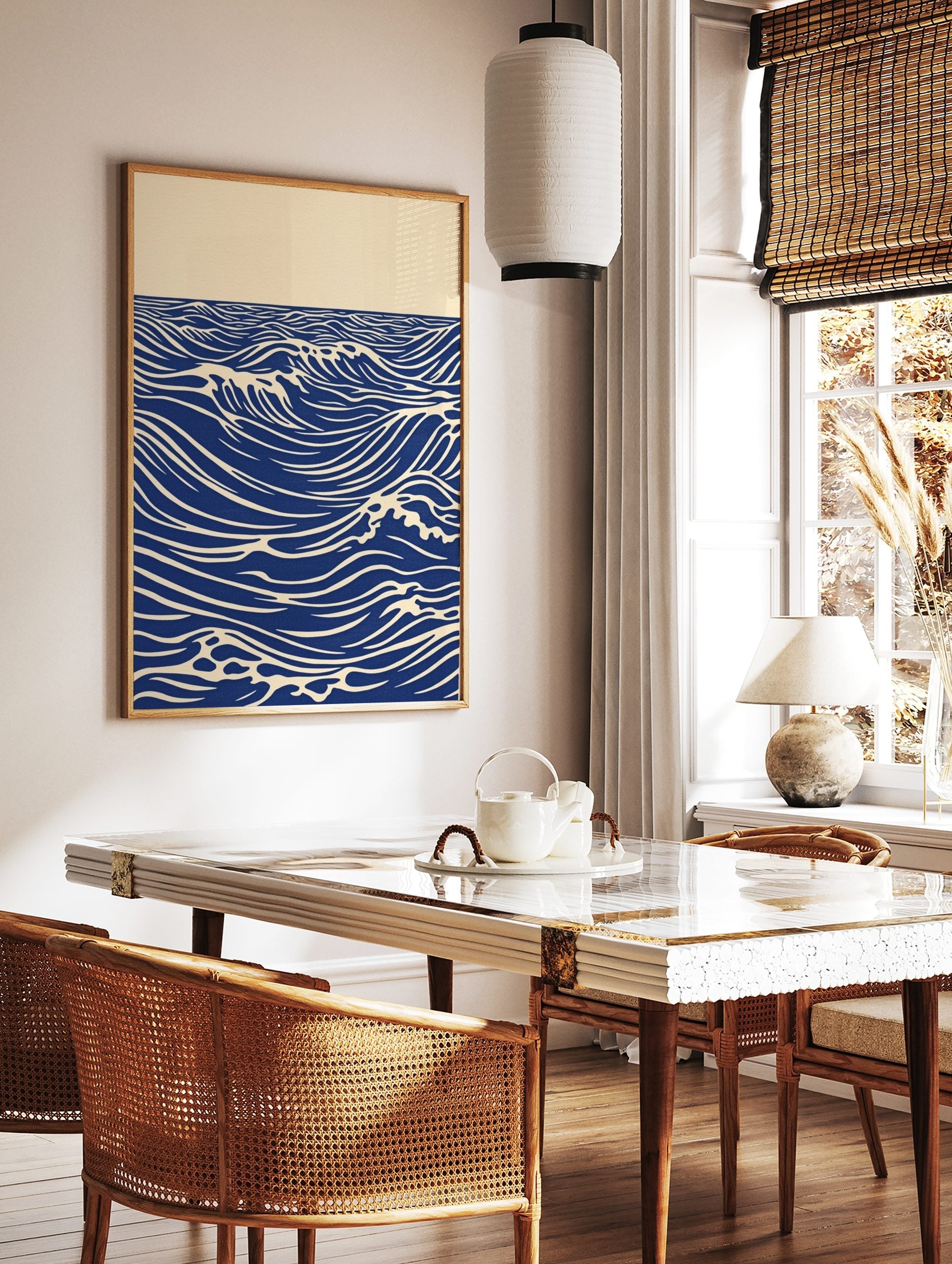 Stylised blue ocean waves with white crests and horizon line on an unframed paper print, in a styled room mockup