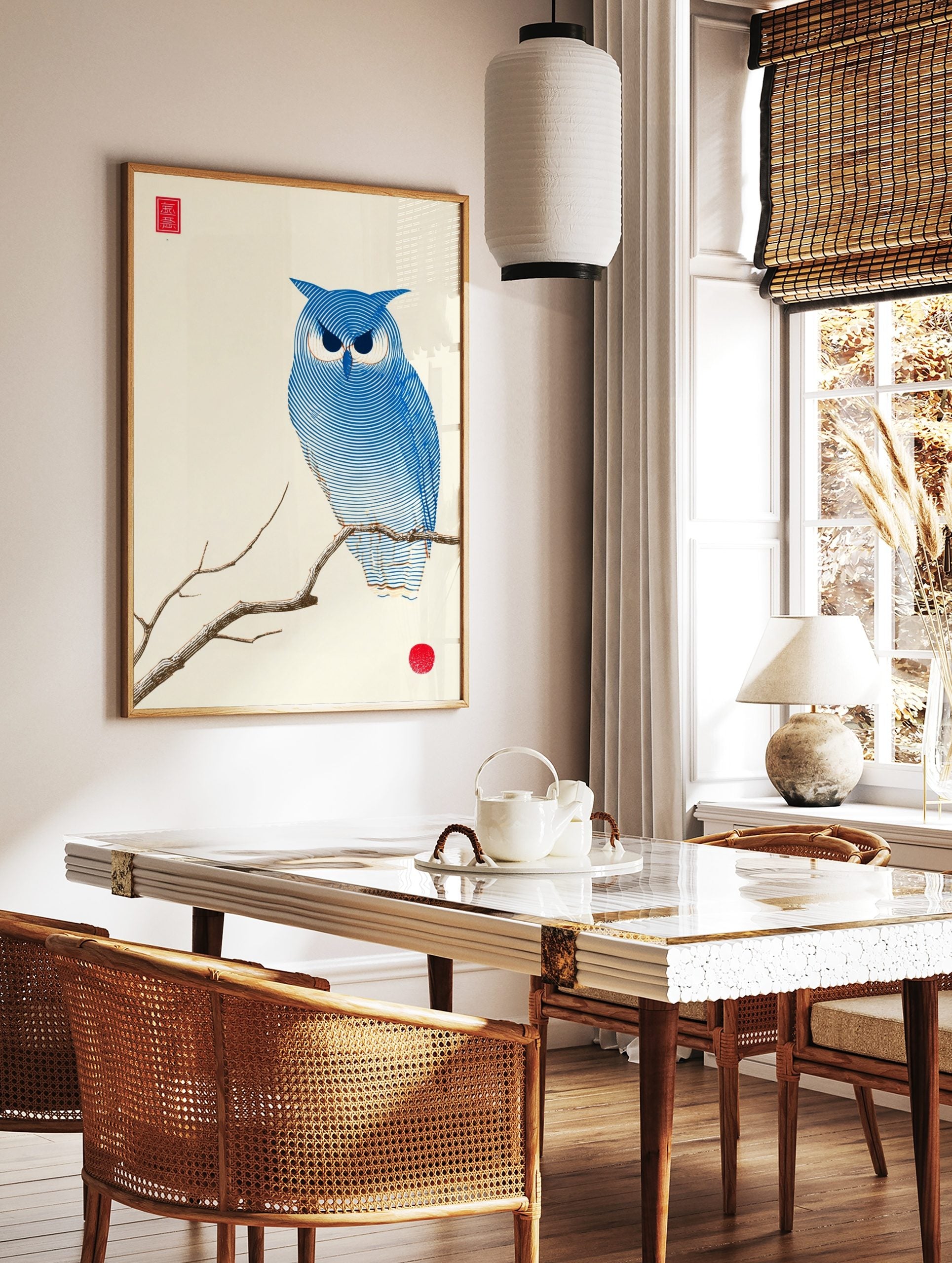 Blue owl illustration on a branch with concentric lines, red seal, and red circle on off-white, in a styled room mockup