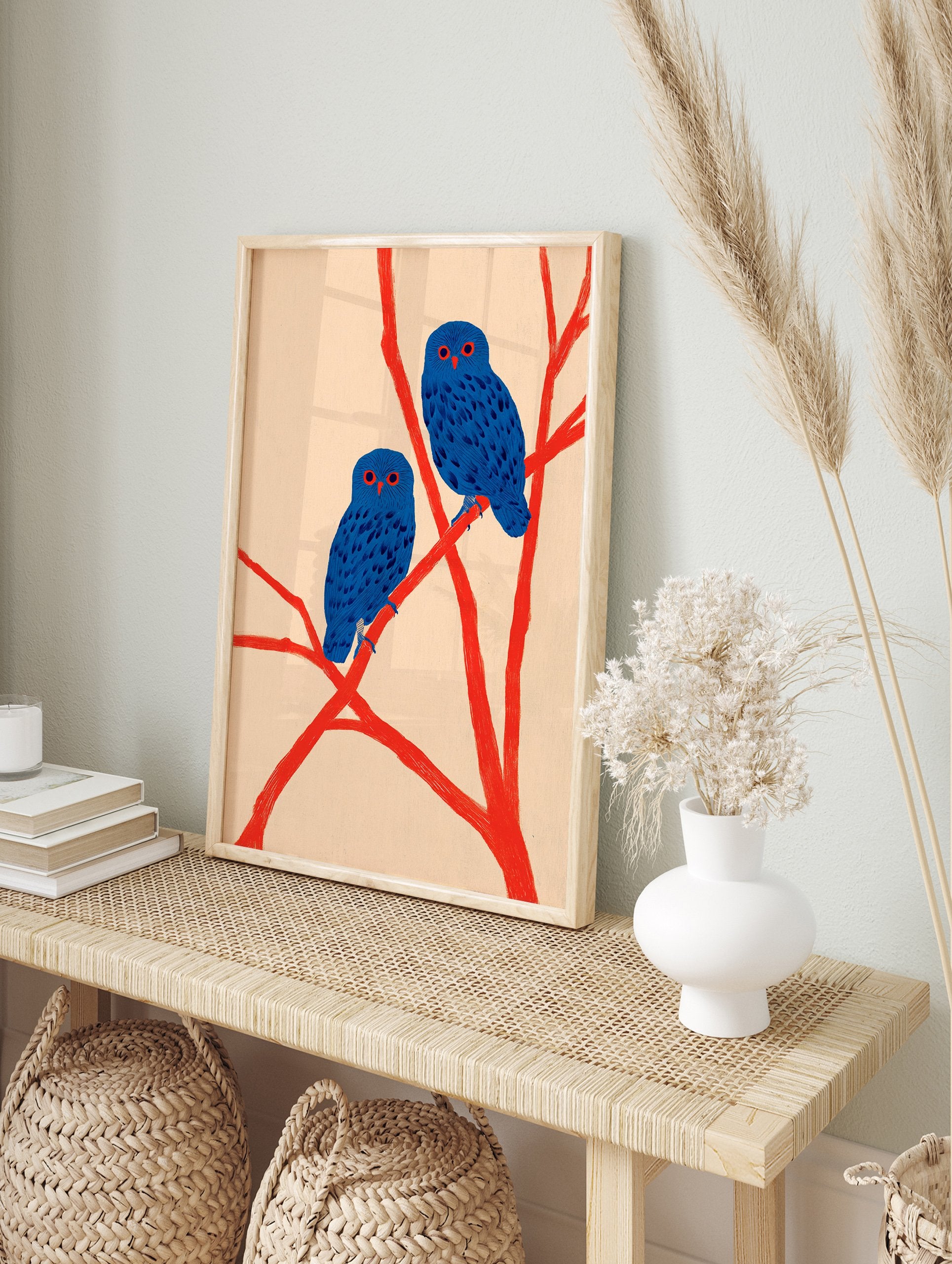 Two blue owls with red eyes perch on bright red branches against a light background, in a modern illustration wall art print. - Image 3