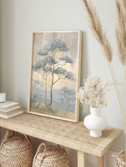 Illustrative blue pine trees in a misty landscape with mountains and textured sky, in an alternate framed mockup