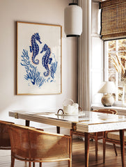 Two blue seahorses with orange outlines, surrounded by blue coral on a white background, in an, in a styled room mockup