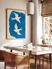 Two white illustrative birds flying against a textured blue background with Japanese text and red, in a styled room mockup