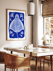 Ornate blue and white stingray illustration with decorative fan-like elements on a deep blue, in a styled room mockup