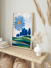 Modern landscape print with a blue sun, orange centre, radiating blue brushstrokes, green, in an alternate framed mockup