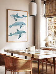 Three illustrative blue whales in watercolour style on a white background, arranged vertically, in a styled room mockup