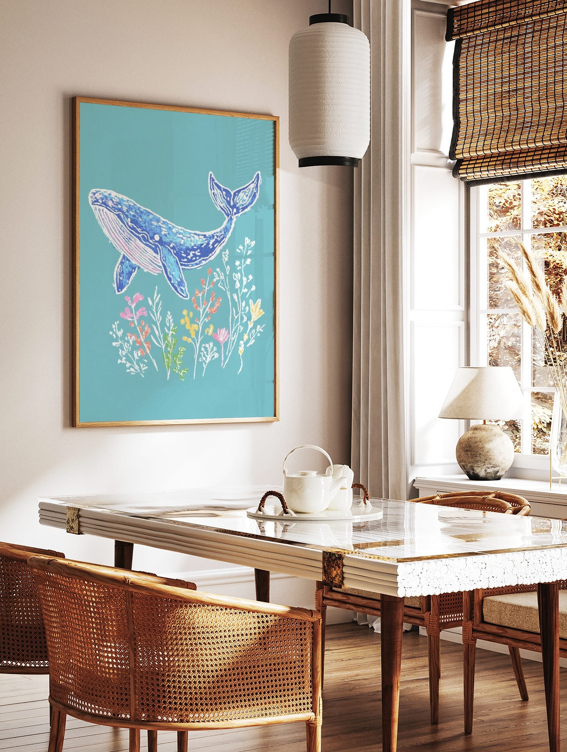 Illustrative blue whale art print with pink accents, swimming above colourful underwater plants on, in a styled room mockup