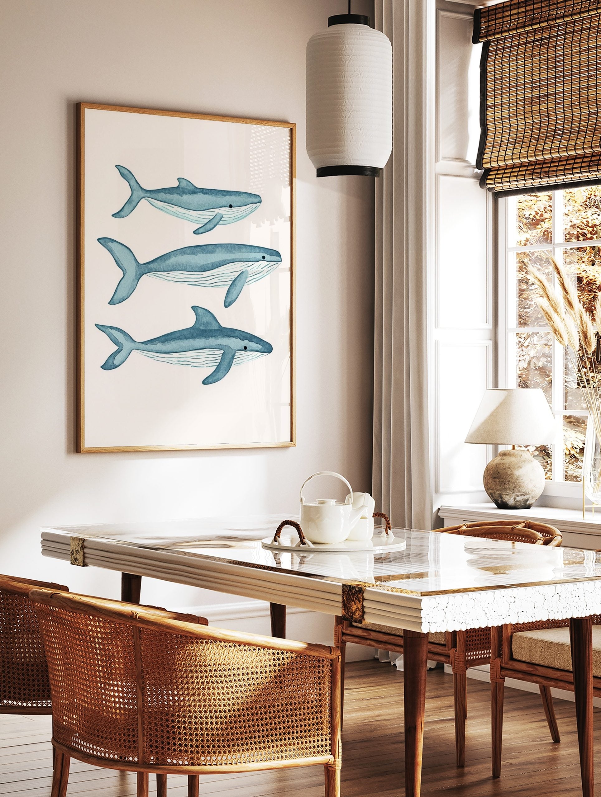 Three blue watercolour whale illustrations, swimming right on a white background, with visible fins, in a styled room mockup