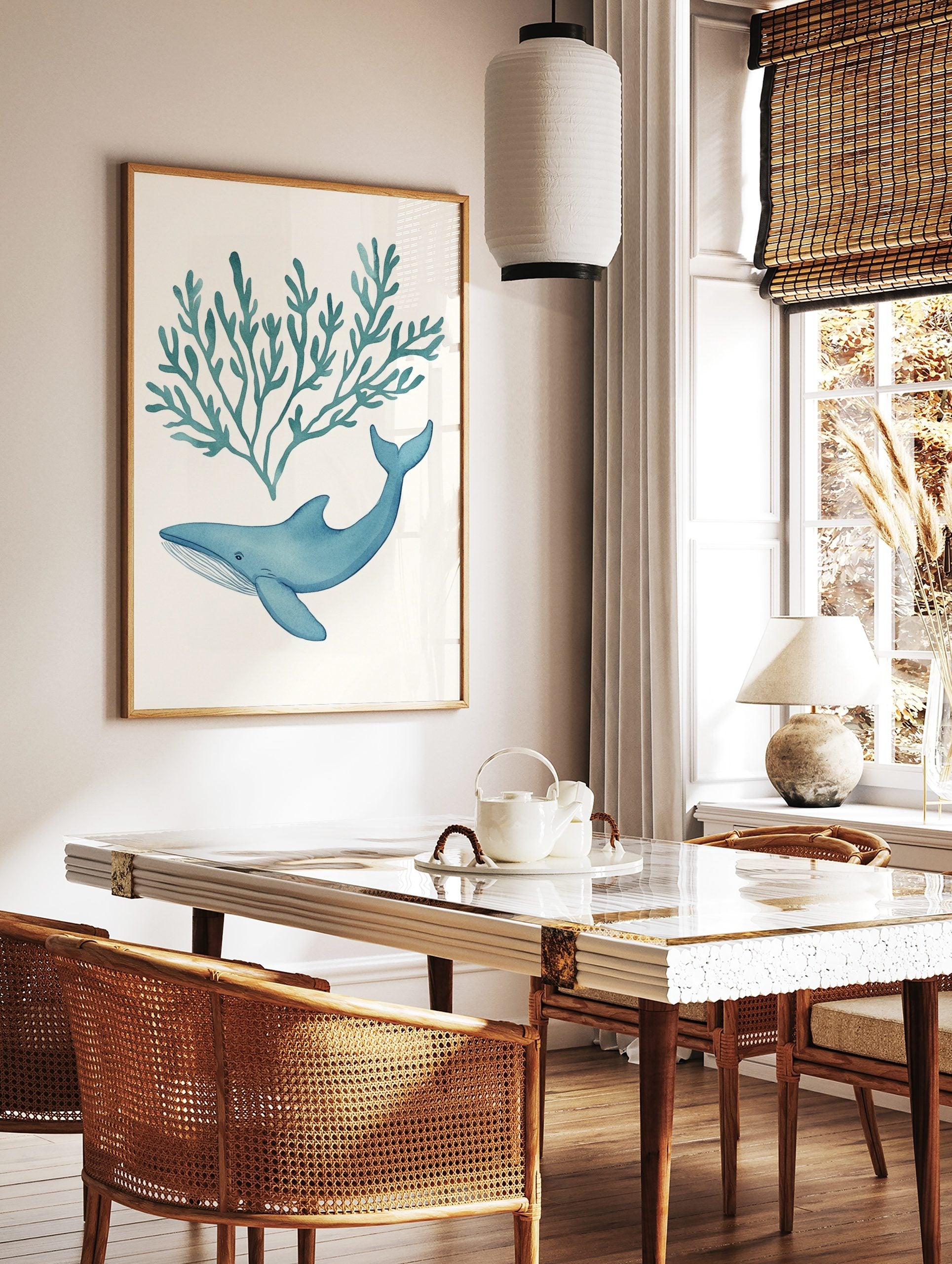 Blue watercolour whale swimming below teal seaweed illustration on white background, in a styled room mockup