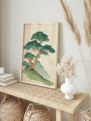 Illustrative print of a gnarled bonsai-style tree with dense green leaves on a grassy hill, in an alternate framed mockup