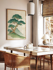 Illustrative print of a gnarled bonsai-style tree with dense green leaves on a grassy hill next to, in a styled room mockup