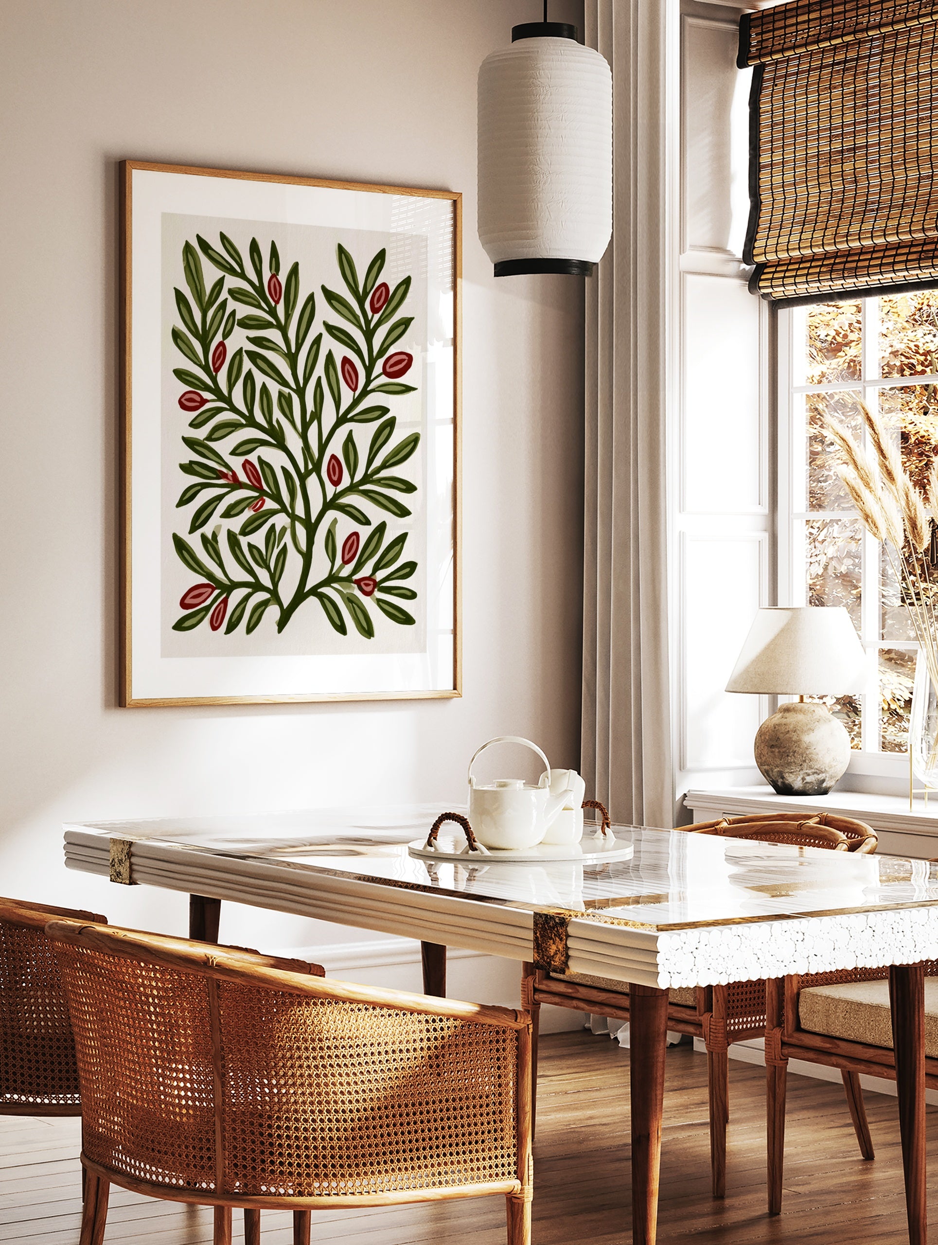 Botanical illustration print of green leafy branches with red berries on a cream background, in a styled room mockup