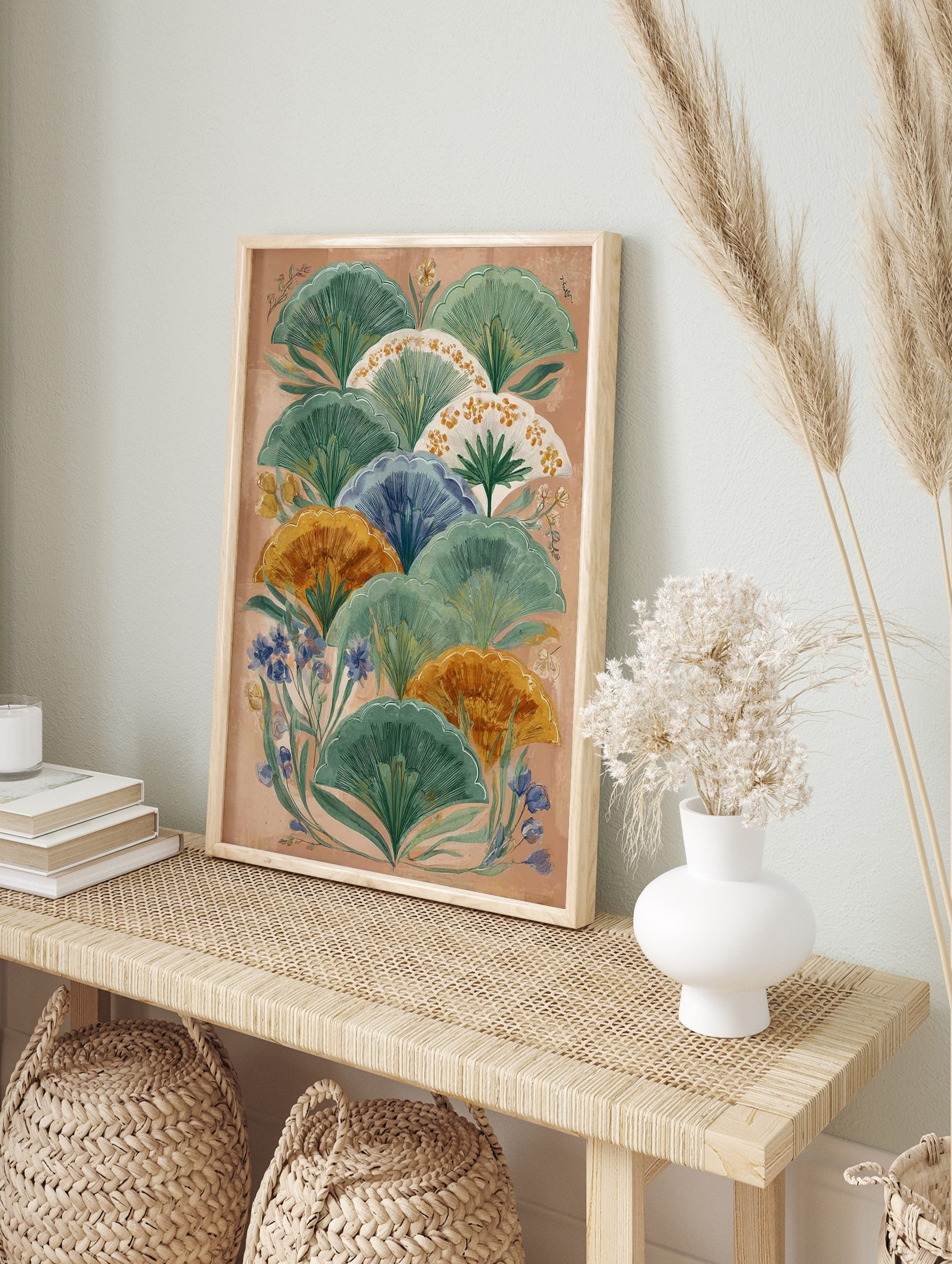 Illustrative botanical wall art with layered green, orange, and blue fan-shaped leaves on a, in an alternate framed mockup