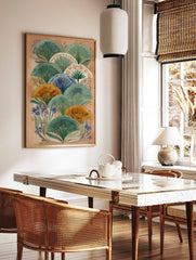 Illustrative botanical wall art with layered green, orange, and blue fan-shaped leaves on a peach, in a styled room mockup