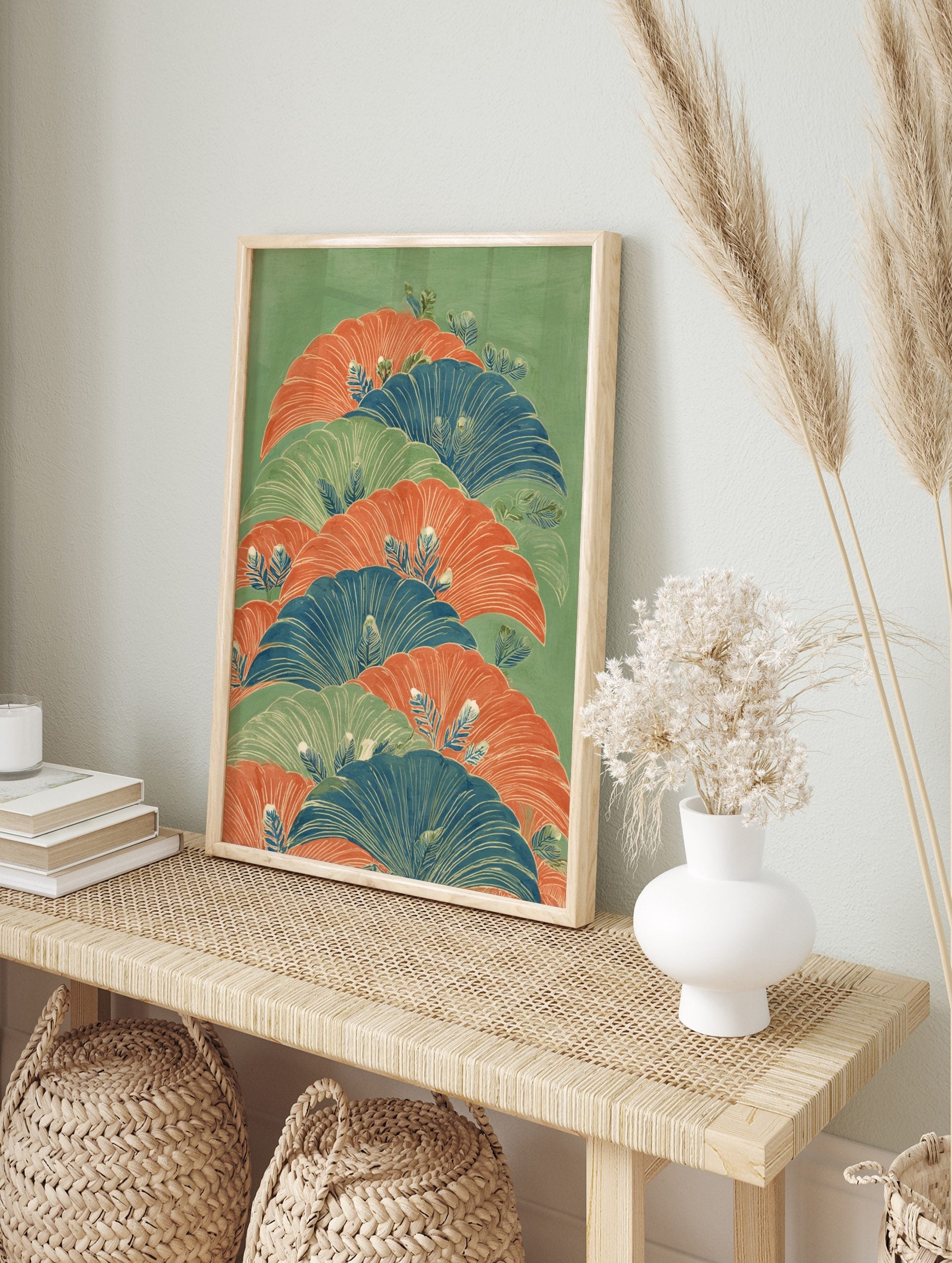 Illustrative botanical wall art with layered fan-like leaves in orange, blue, and green on a, in an alternate framed mockup
