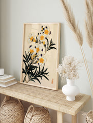 Botanical illustration of white flowers with yellow centres, dark purple accents, and green, in an alternate framed mockup