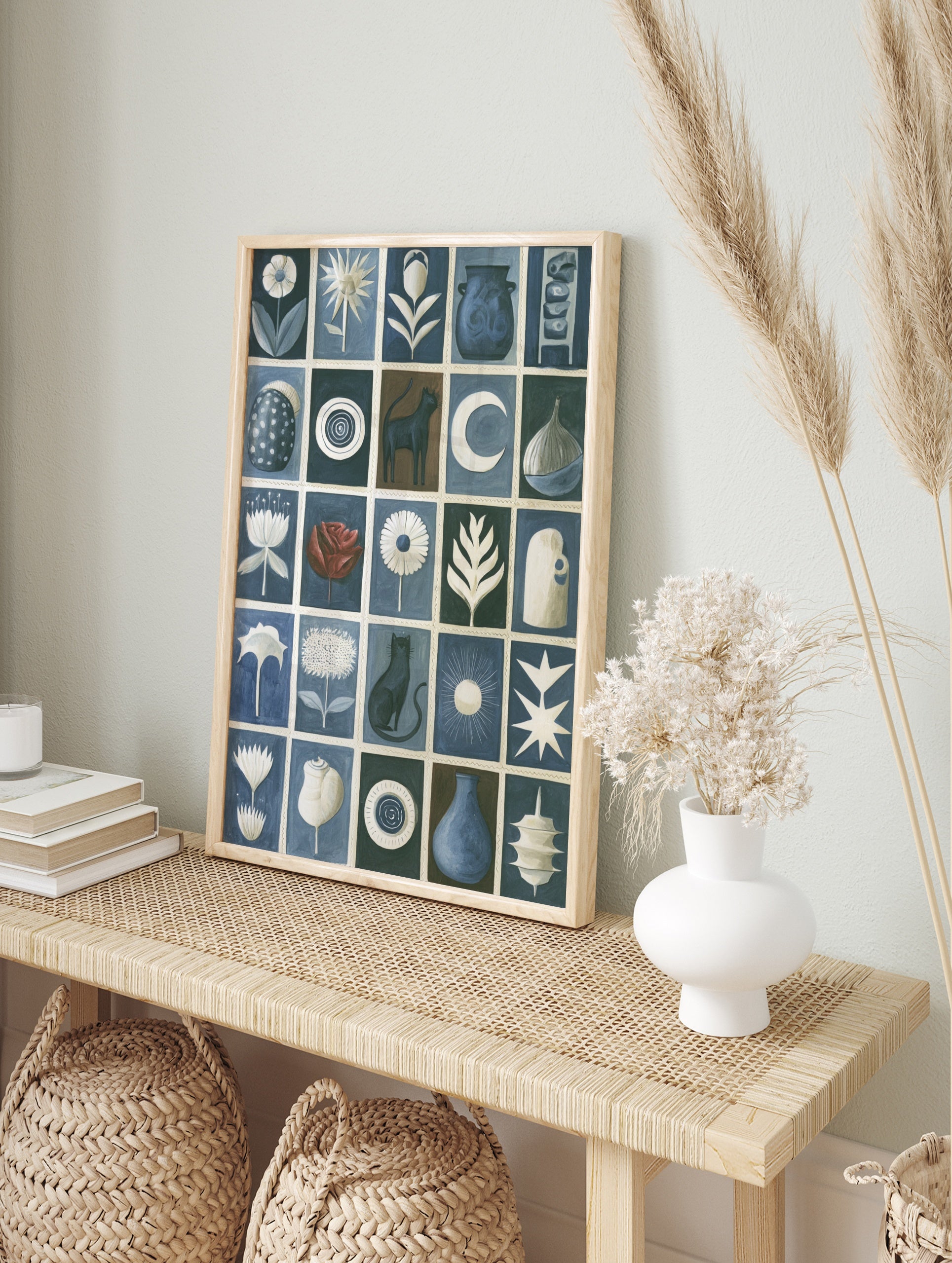 Grid artwork with cats, flowers, pottery, and celestial symbols in blue, white, and brown on, in an alternate framed mockup