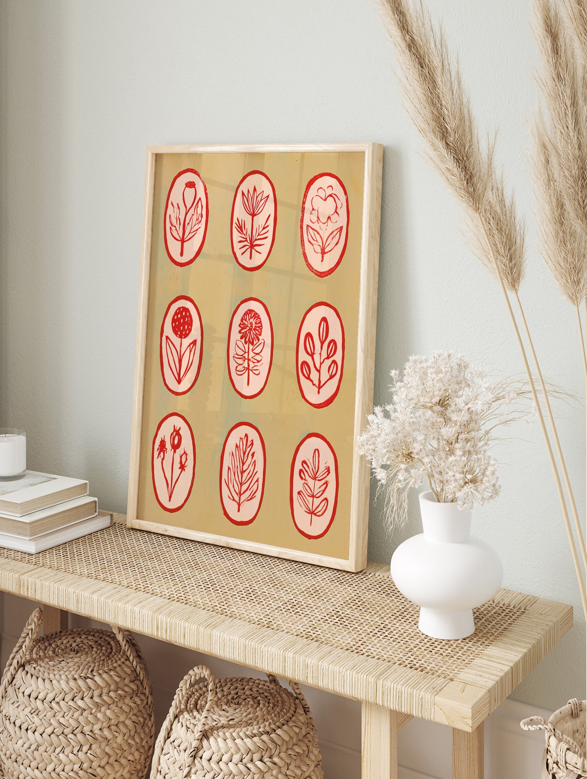 Botanical illustration wall art with nine red line-art flowers in oval frames on a light tan, in an alternate framed mockup