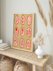 Botanical illustration wall art with nine red line-art flowers in oval frames on a light tan, in an alternate framed mockup