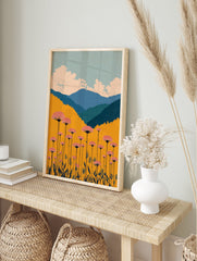 Vibrant botanical landscape wall art featuring pink flowers, golden field, blue mountains, and a cloudy sky. - Image 3